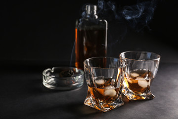 Glasses of cold whiskey on dark background