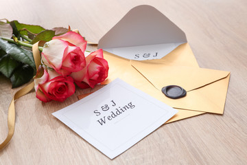 Wedding invitations and flowers on table