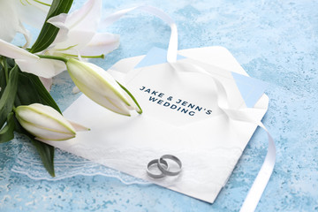 Wedding invitation, rings and flowers on table