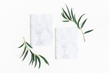 Paper blank, eucalyptus branches on white background. Wedding invitation card. Flat lay, top view, copy space