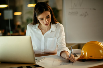 Young woman architect working on a project. Female engineer at her desk.
