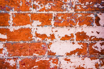 Rusty brick wall. Empty and rusty old brick wall texture. Distressed wall surface. Grunge stonewall background with peeling paint.