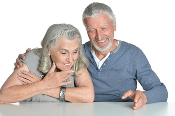 Portrait of hugging senior couple sitting at table