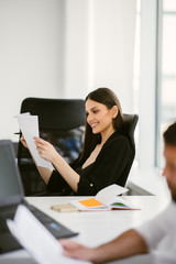 Colleagues working together at the office. Managers go through papers during a meeting.