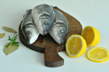 fresh fish with lemon and Rosemary on wooden board. mediterranean diet . healthy food