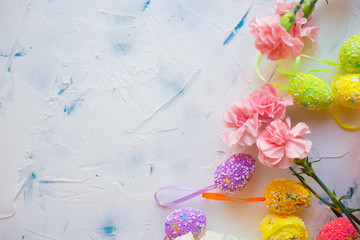  Easter eggs and flowers on a light background. Holiday card for Easter. Colored eggs and pink flowers