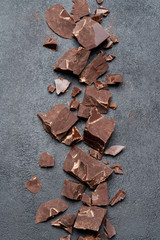 Frame or border made of Dark or milk organic chocolate pieces on dark concrete backgound