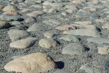 Background texture of gardens pavement decorated wirh big stones and gravel around.