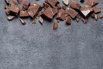 Frame or border made of Dark or milk organic chocolate pieces on dark concrete backgound