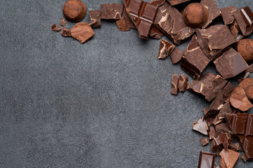 Frame or border made of Dark or milk organic chocolate pieces on dark concrete backgound