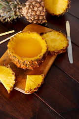 Fresh fruit juice with exotic pineapple on a wooden brown table. A composition made of ananas. Top wiev. 