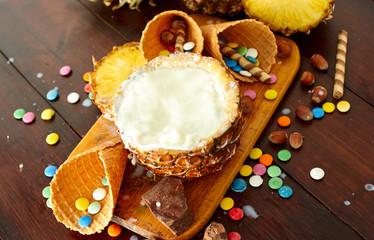 Splash milk pineapple drink on a wooden brown table. Summer ice cream and cocktails set. Top view