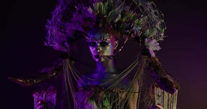 Portrait of beautiful female with complex floral make-up posing in creative lighting. Body painting fashion project. Model and property released. 4K UHD RAW FOOTAGE