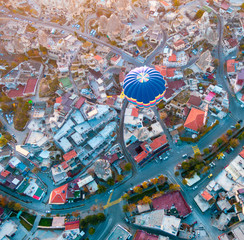 Hot air balloon flying at dawn over the city of Cappadocia in Turkey. View from above.