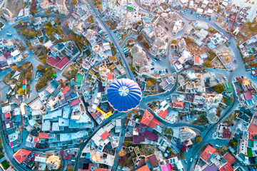 Hot air balloon flying at dawn over the city of Cappadocia in Turkey. View from above.