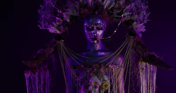 Portrait of beautiful female with complex floral make-up posing in creative lighting. Body painting fashion project. Model and property released. 4K UHD RAW FOOTAGE