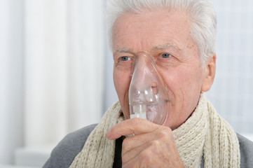 Close up portrait of ill senior man portrait with inhaler