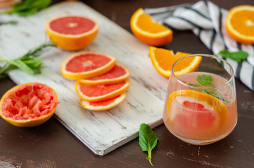 Grapefruit and oranges are on the wooden table.