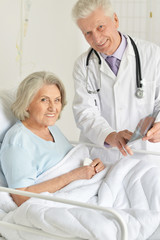 Close up portrait of senior woman in hospital with caring doctor