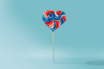 Heart shaped lollipop on a blue background. 