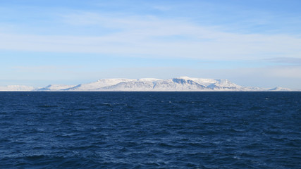 Atlantik um Reykjavik und schneebedeckte Hügel mit blauem Himmel