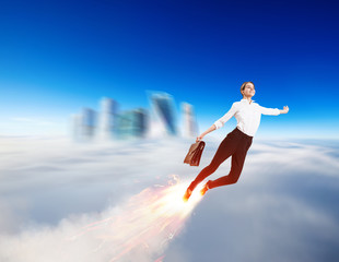 Fototapeta na wymiar Young businesswoman flying like a rocket in blue sky.