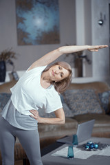 Mature woman bends to the left. Yoga