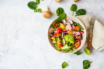 Fotobehang Healthy salad with bio organic vegetables, green vegan meal with avocado, pepper, radish, tomatoes, lettuce, cabbage, spring colorful salad closeup, clean eating concept top view © marrakeshh