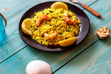 Paella with shrimp on a blue wooden background