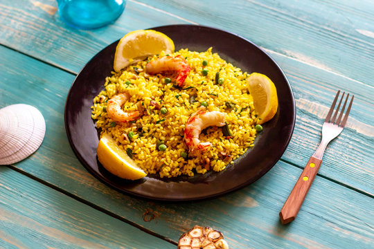 Paella with shrimp on a blue wooden background