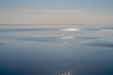 dramatic seascape calm sea in spring with broken pieces of ice on the surface