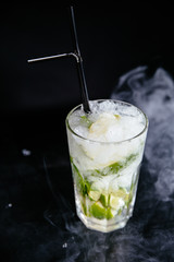 Mojito cocktail on black smokey background.