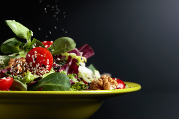 Green salad with cherry tomatoes,  sesame, walnuts and vegetable oil.