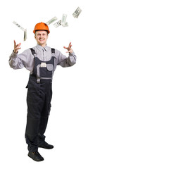 A working engineer in a helmet throws money around. The builder made a very good deal and was pleased that he picked up a big sum. isolated