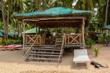 El Nido Beach, Philippines - wooden lounge area on a sandy beach