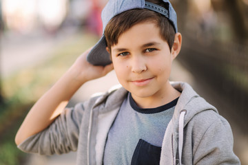 Portrait of little boy in cap. Stylish boy walking in the city