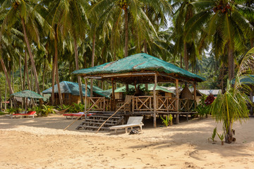 El Nido Beach, Philippines - wooden lounge area on a sandy beach
