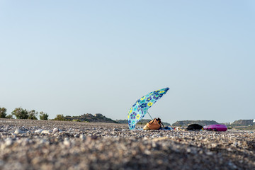 Fototapeta na wymiar Beach bag and towels under sun umbrella on a beach