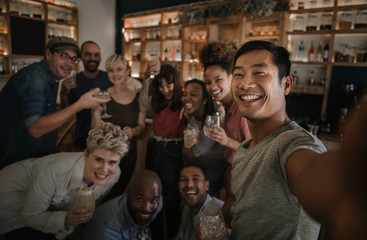 Friends taking selfies while having fun in a bar