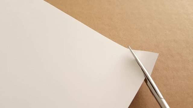 utting corners idiom Briticism hand takes sheet of paper and cutting corners by scissors doing something so easily and cheaply as possible