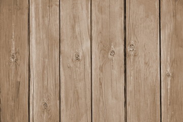 A fence from the tightly nailed wooden planks. Natural color of pine wood covered with transparent varnish. Sepia toned. Close-up. Selective focus. Copy space. 
