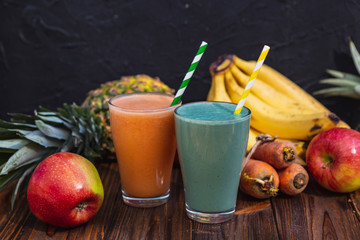 glass is filled with fresh and useful smoothie made from spicy juicy vegetables and fruits. Drink is sitting on a wooden table near the ingredients from which it is cooked illuminated by warm daylight
