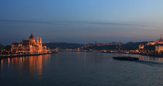 A view of historical Hungarian Parliament building and Danube river at night. Time lapse