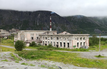 Destroyed Stalin's station on the background of the mountains in the city of Kirovsk, Murmansk...