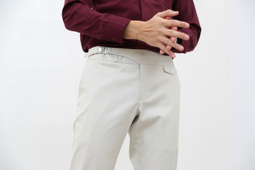 close-up of a handsome man in red formal shirt and white long trousers.
