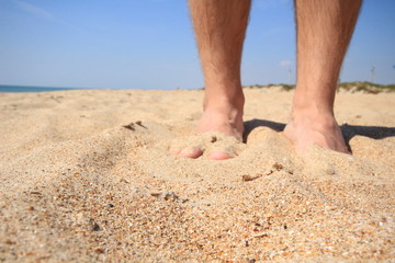 Obraz na płótnie Canvas feet in the sand on the beach