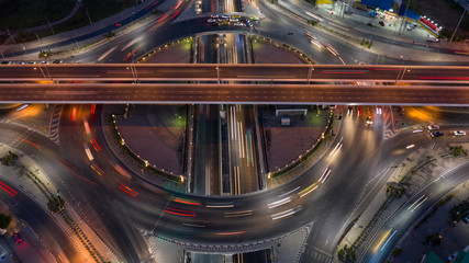 Fototapeta na wymiar Road roundabout intersection in the city at night with vehicle car light movement, Aerial view.