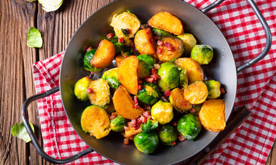 Brussels sprouts potato pan with bacon in rustic style