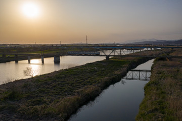 夕暮れの渡良瀬川とローカル列車