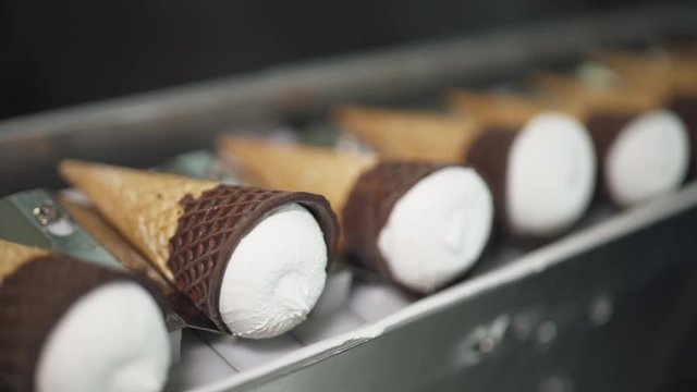 ice cream production, transportation waffle-cone with plombir ice cream on production line, dairy products.